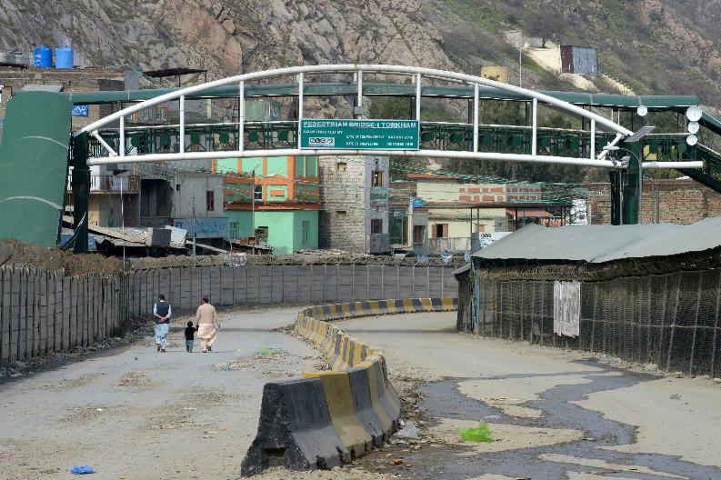 Men with a child walk along a deserted road near the Pakistan-Afghanistan border in Torkham some 54 kms from Peshawar on March 16, 2020. (AFP)