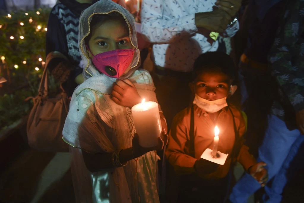 Christian devotees hold candles during an Easter vigil procession at Central Brooks Memorial Church, in Karachi on April 4, 2021. (AFP)