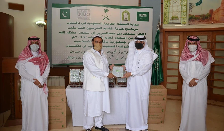 Pakistani Punjab's Minister of Religious Affairs, Sheikh Saeed Al-Hassan (second from left) receives a packet of dates from Saudi Arabia's ambassador to Pakistan Nawaf bin Saeed Al-Maliki (second from right) in Pakistan on April 14, 2021. (SPA)