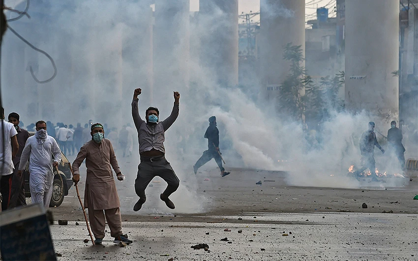 Police use tear gas to disperse supporters of Tehreek-e-Labbaik Pakistan (TLP) during a protest in Lahore on April 12, 2021, after the arrest of their leader, who has called for the expulsion of the French ambassador. (AFP)