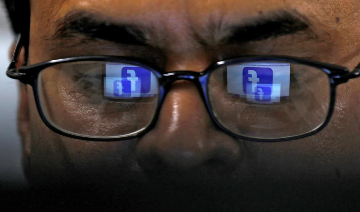 Reflection of Facebook logo appears in glasses of a Pakistani man in Karachi on April 1, 2019. (REUTERS/File)