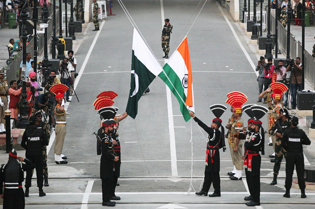 Pakistani Rangers (wearing black uniforms) and Indian Border Security Force (BSF) officers lower their national flags during parade on the Pakistan's 72nd Independence Day, at the Pakistan-India joint check-post at Wagah border, near Lahore, Pakistan August 14, 2019. (Reuters/File)