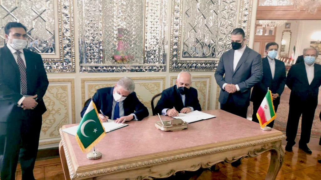 Pakistan's Foreign Minister Shah Mahmood Qureshi (second from left) is signing memorandum of understanding with Iranian Foreign Minister Javad Zarif (fourth from right) in Iran on April 21, 2021. (Photo courtesy: Pakistan Foreign Office)
