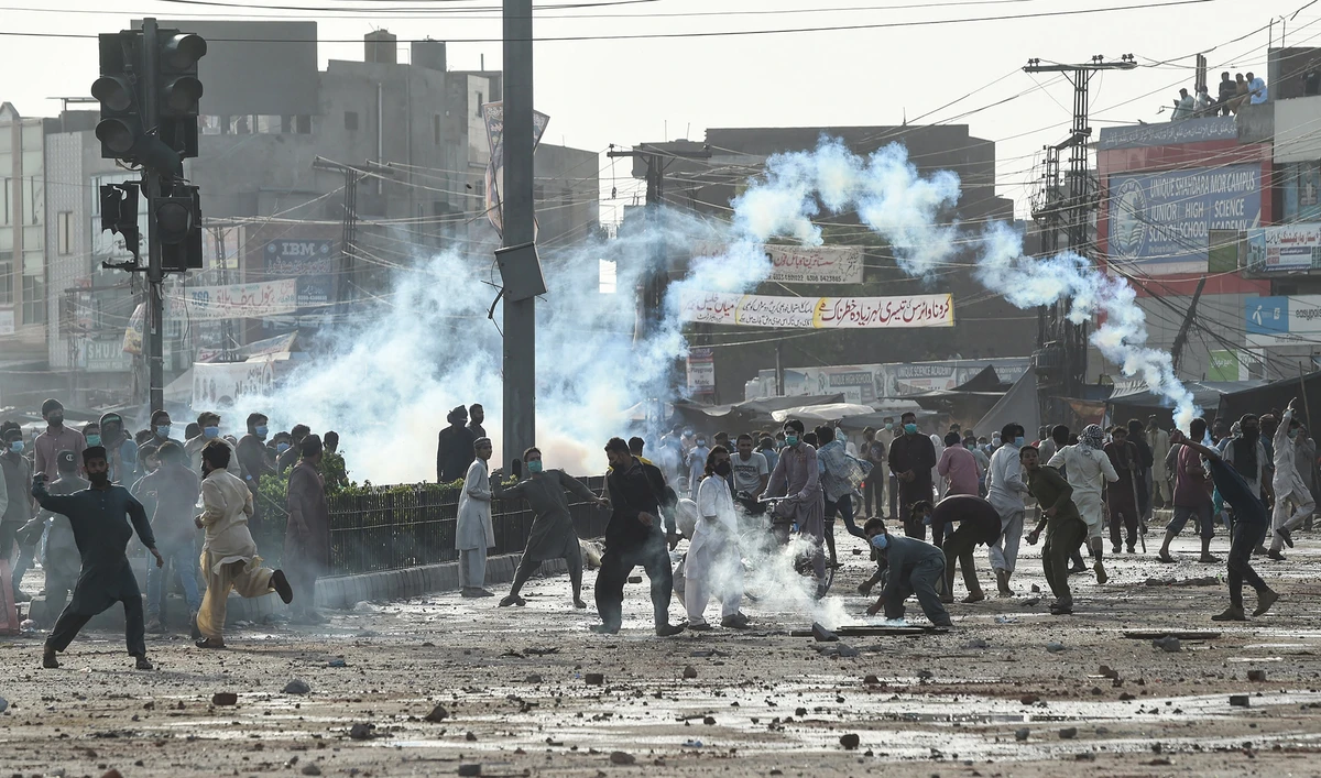Supporters of Tehreek-e-Labbaik Pakistan (TLP) party throw stones towards police during a protest against the arrest of their leader Saad Rizvi, in Lahore, Pakistan, on April 13, 2021. (AFP)