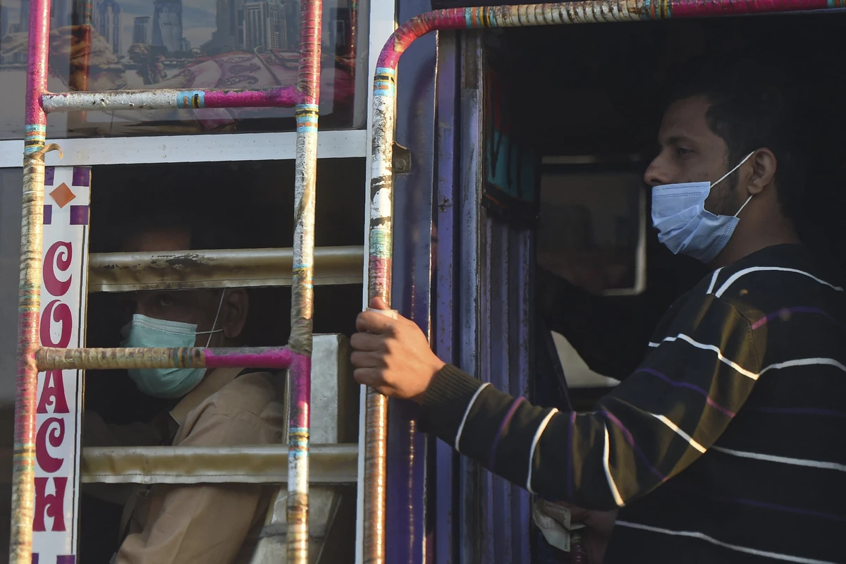 People wearing facemasks as a preventive measure against the Covid-19 coronavirus travel on a passenger bus in Karachi on November 26, 2020. (AFP)
