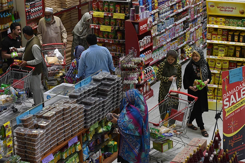 Muslim people buy grocery items at a store ahead of the Holy month of Ramadan in Peshawar on April 5, 2021. (AFP)