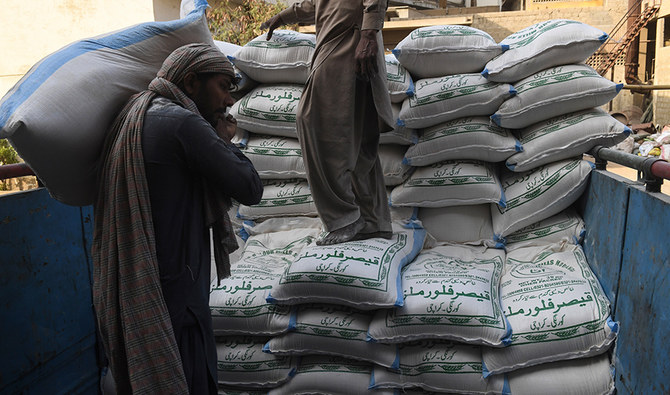 Labourers load sacks of wheat flour at a market in Karachi on January 20, 2020. (AFP/ File)