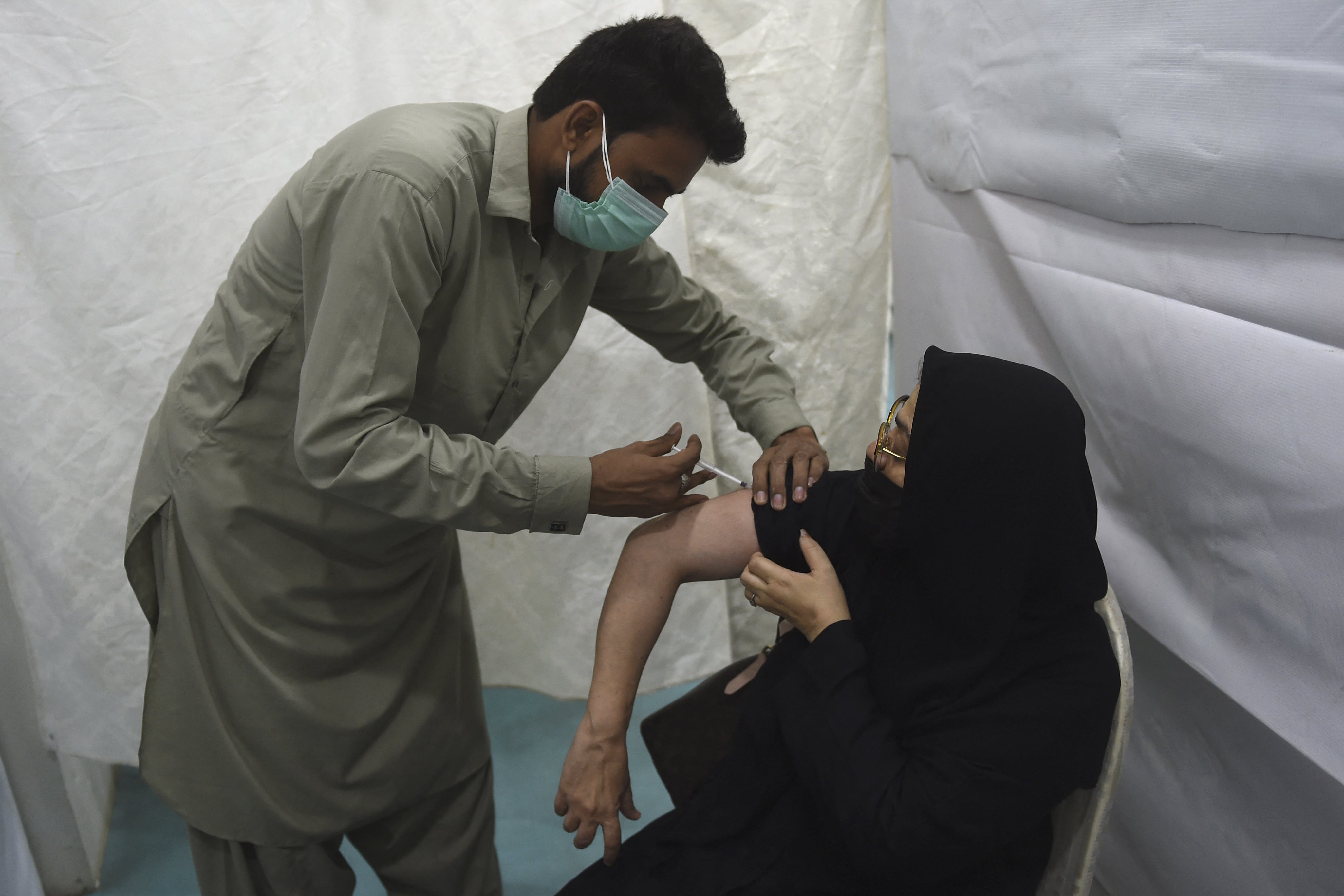 A health worker incoluates a woman with a dose of Sinopharm vaccine against the Covid-19 coronavirus at a vaccination centre in Karachi on May 3, 2021. (AFP)