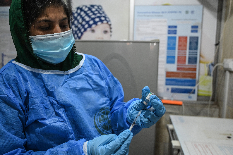 A medical attendant prepares to innoculate a senior citizen with a Chinese-made Sinopharm vaccine against the Covid-19 coronavirus, at a vaccination centre in Islamabad on March 30, 2021. (AFP)