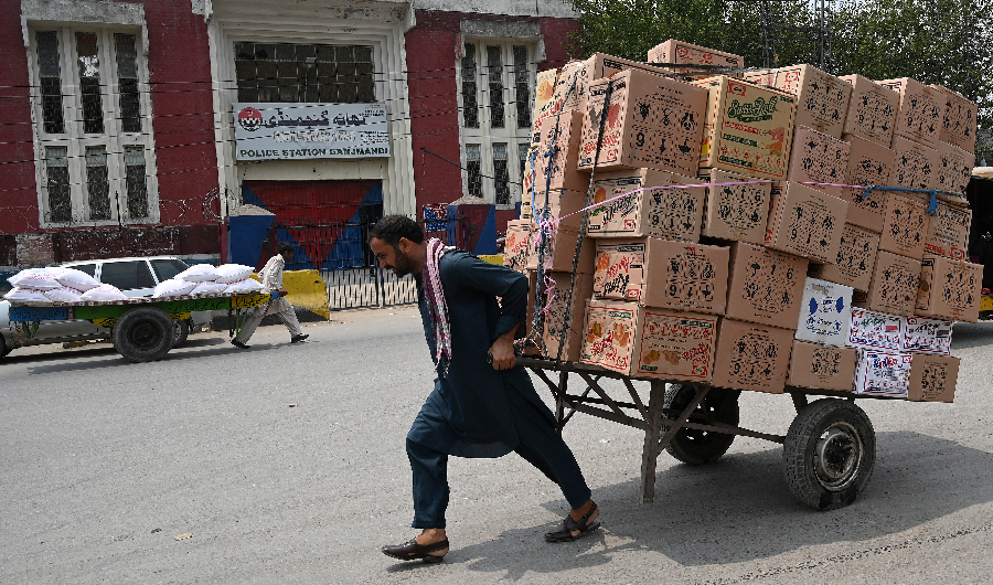 In this picture taken on July 22, 2019, a labourer pulls a loaded cart along a street at a market in Rawalpindi. (AFP)