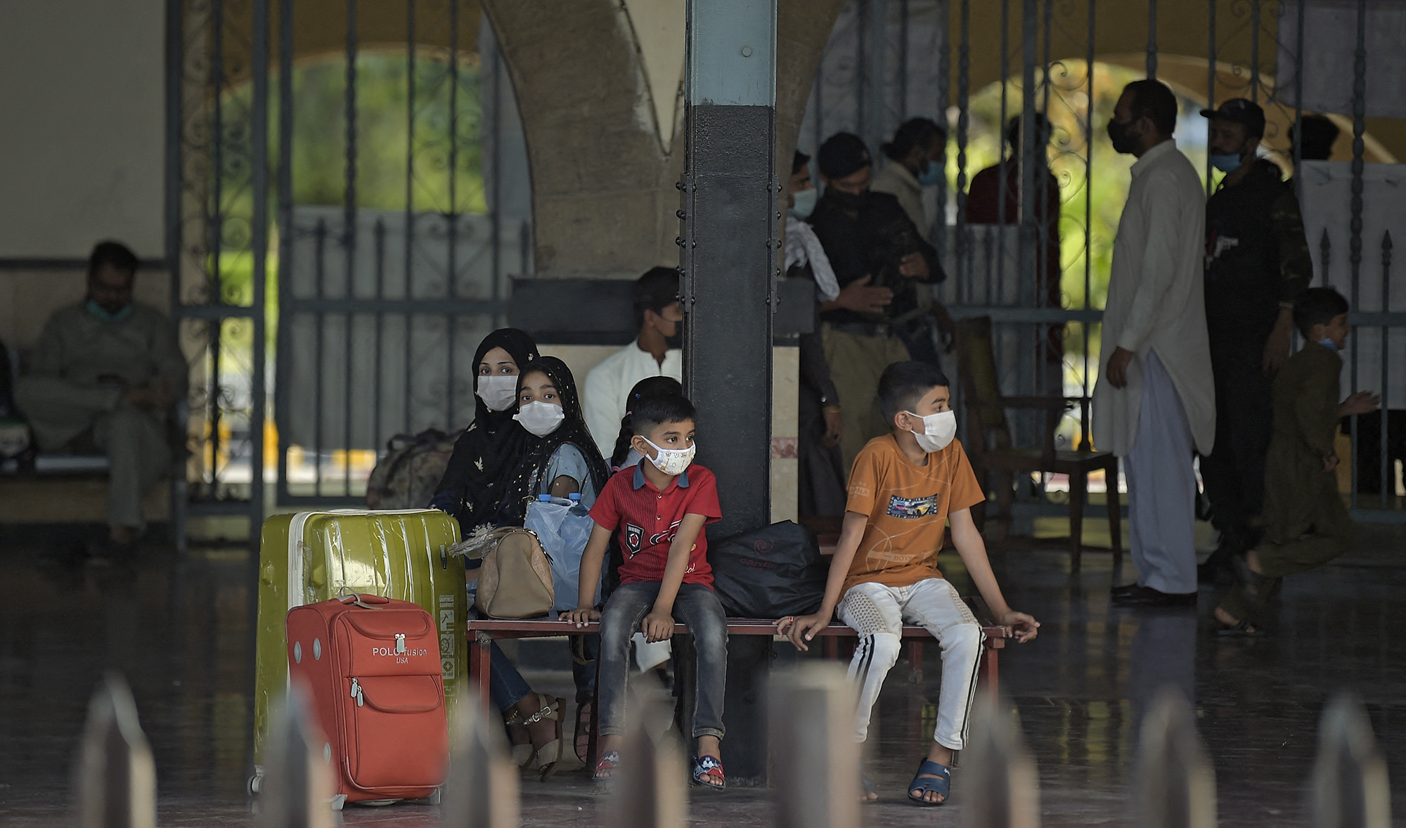 A family waits for a train during a nine-day shutdown in a bid to prevent a surge in Covid-19 cases on Eid Al-Fitr, in Rawalpindi, Pakistan, on May 11, 2021. (AFP)