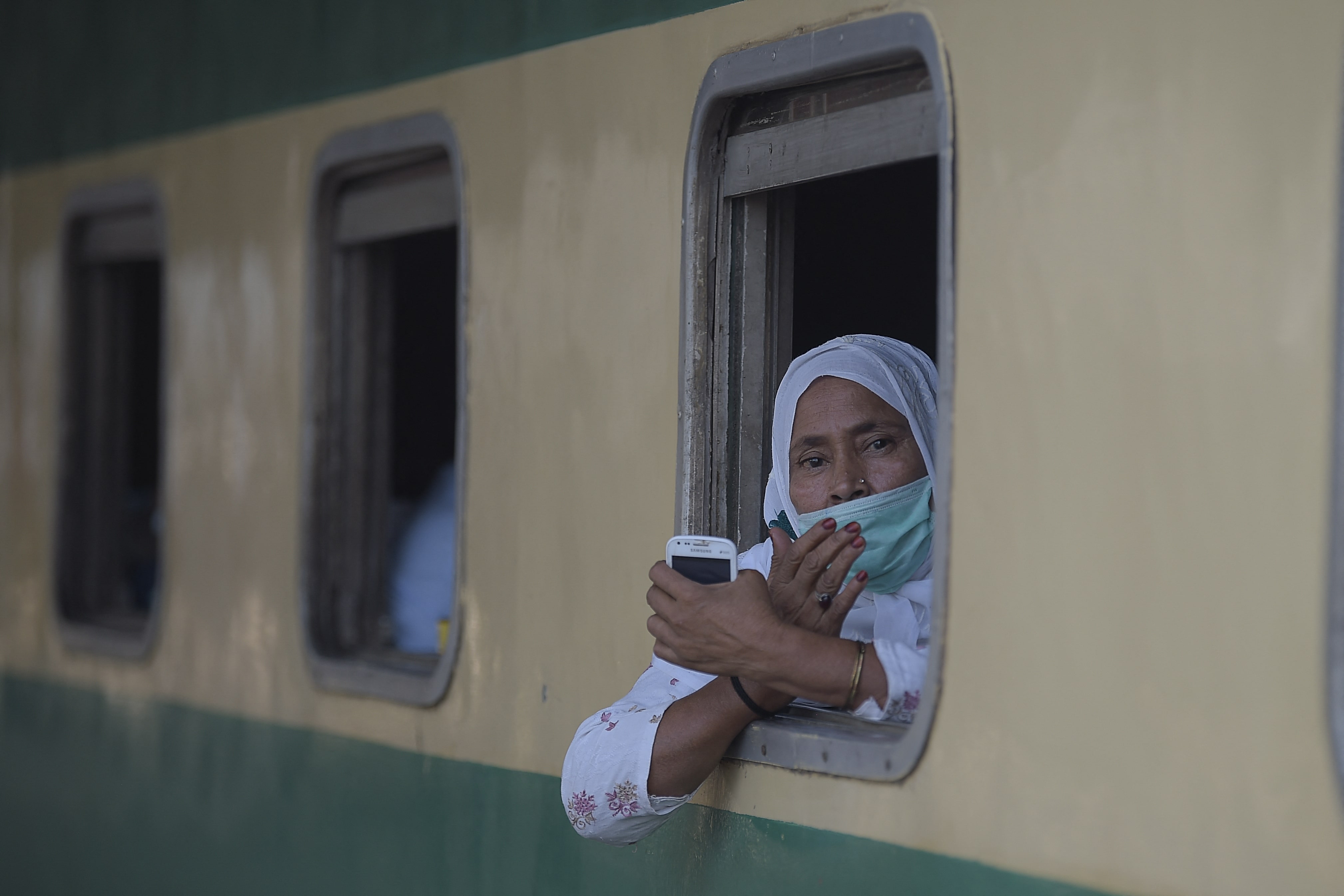 A passenger wearing facemasks looks out from a window of a train during a nine-day shutdown in a bid to prevent a surge in Covid-19 cases on the Muslim holiday of Eid al-Fitr, in Rawalpindi on May 11, 2021. (AFP)