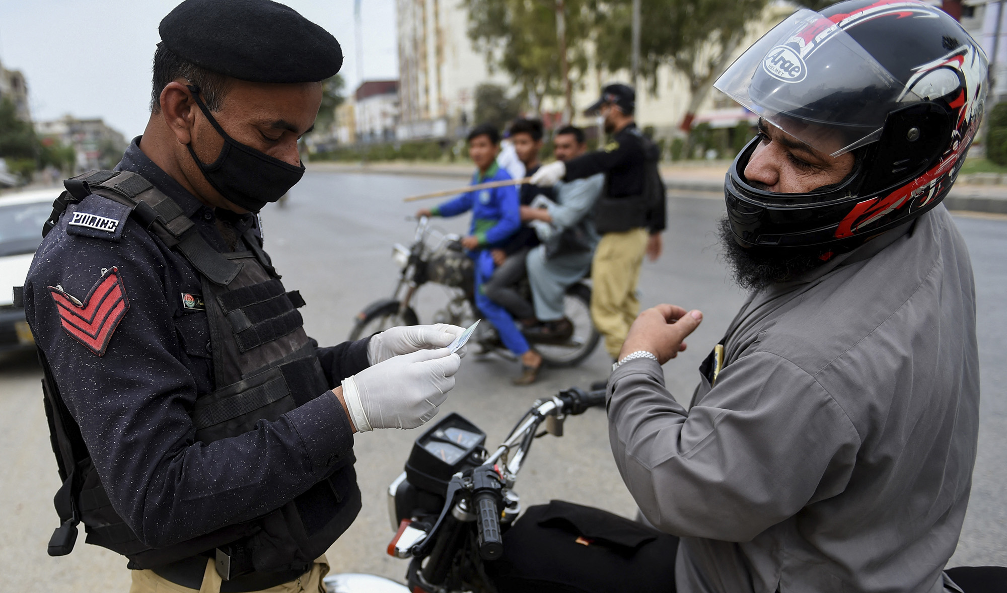 Policeman checks an identity card of a motorcyclist during a lockdown in Sindh province to curb spread of COVID-19, in Karachi, Pakistan, on March 23, 2020. (AFP/File)