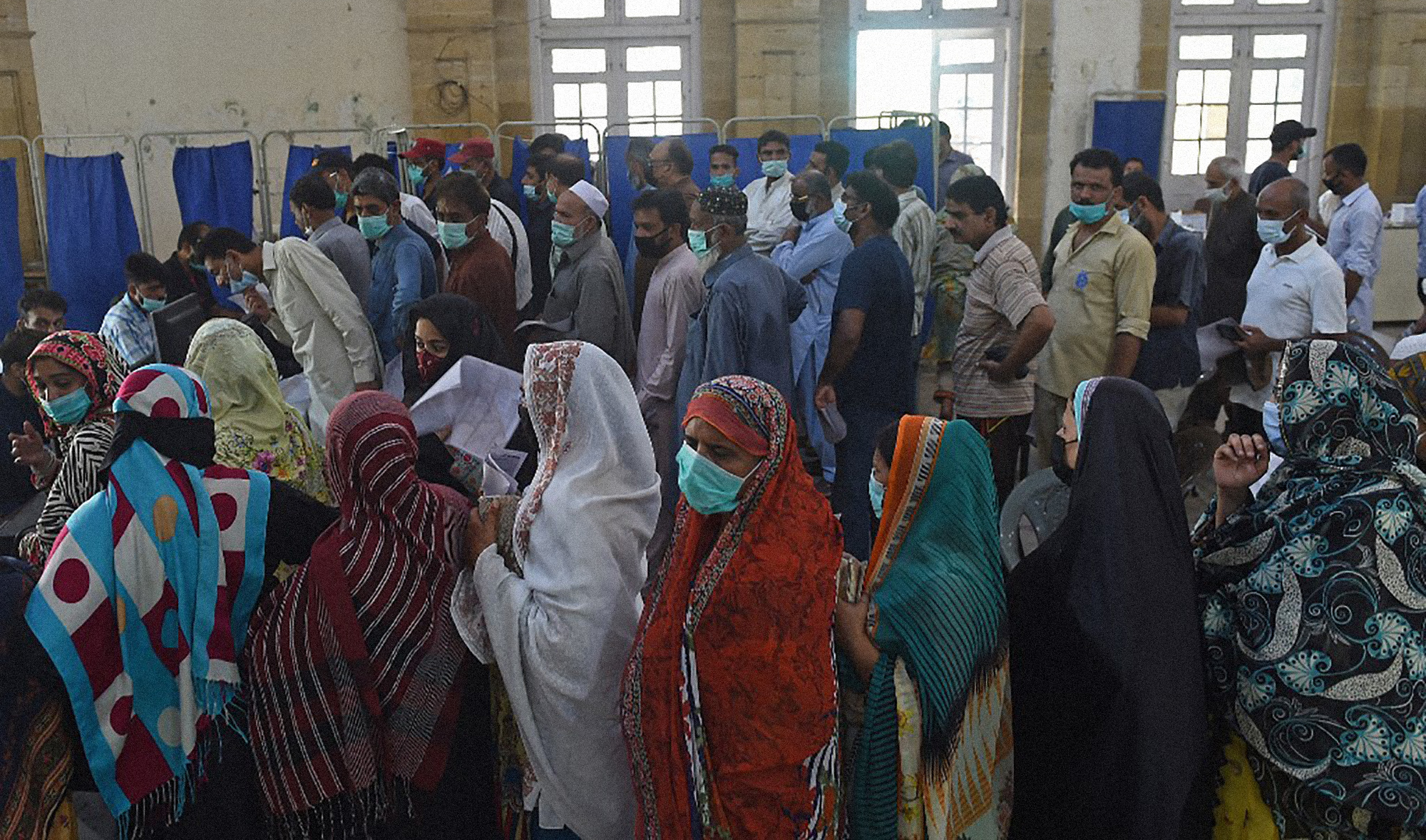 People queue up to register themselves to get inoculated with the jab of COVID-19 coronavirus vaccine at a vaccination camp held in Karachi on May 22, 2021. (AFP)
