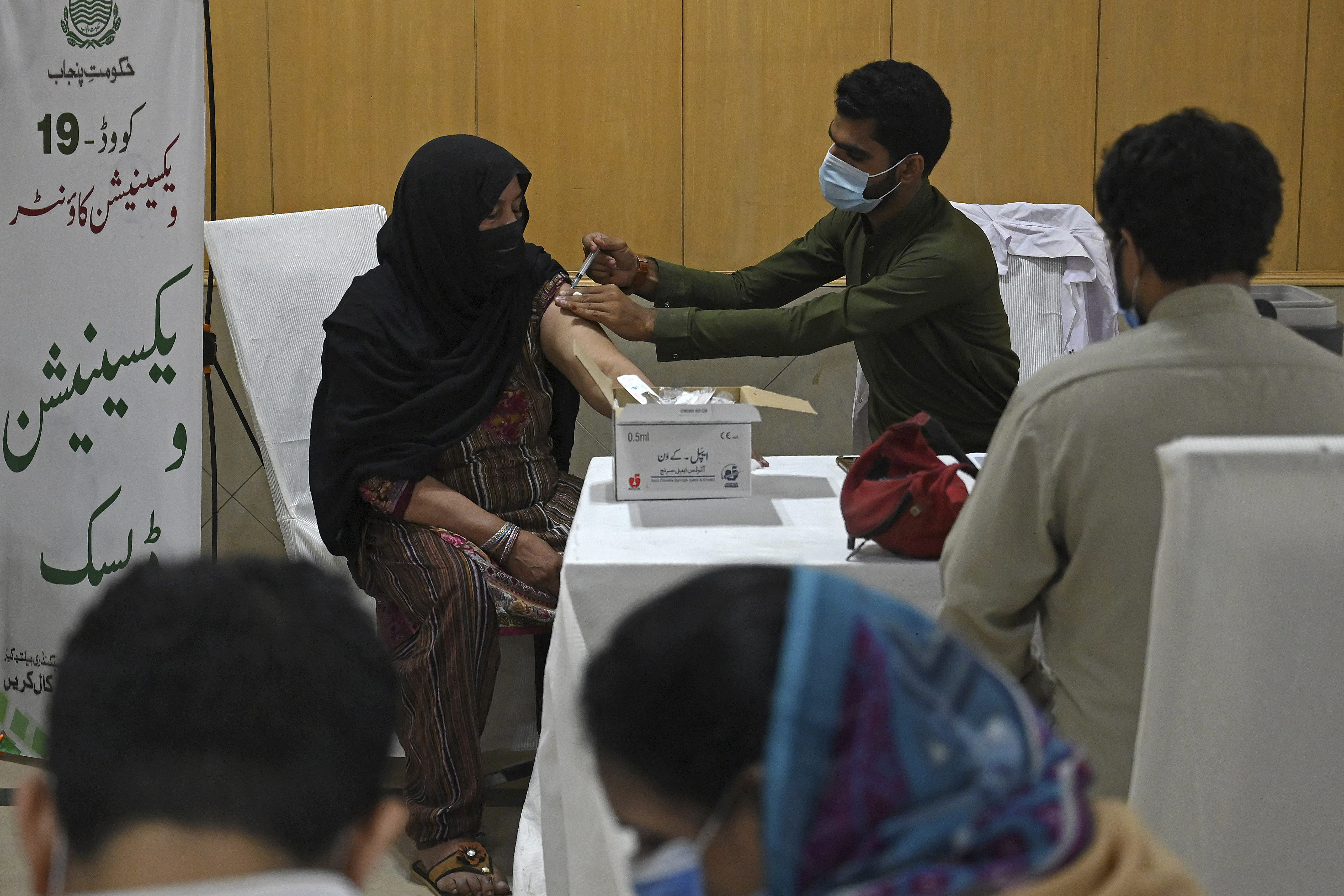 Members of the media can be seen getting inoculated with the Covishield AstraZeneca-Oxford's Covid-19 coronavirus vaccine at the Lahore Press Club in Lahore on May 18, 2021. (AFP)