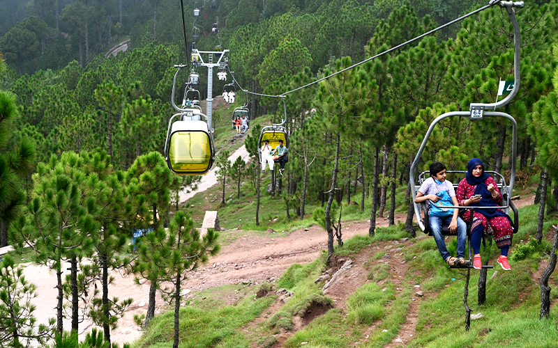 Tourists sit on chairlifts at the Patriata Resort near Murree, some 65 km form Islamabad, Pakistan, on August 16, 2020. (AFP)