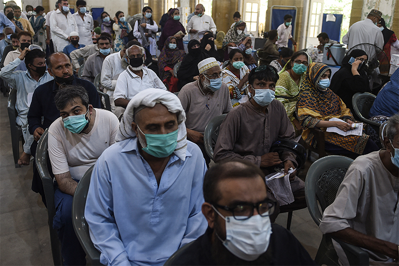 People wait for their trun to get a dose of the Covid-19 coronavirus Sinopharm vaccine at a vaccination camp in Karachi on May 25, 2021. (AFP)