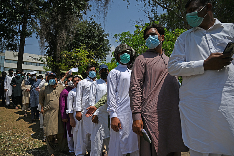 In this picture taken on May 19, 2021, Pakistani nationals, wait in a queue to apply for a visa outside Afghanistan's embassy in Islamabad. (AFP)