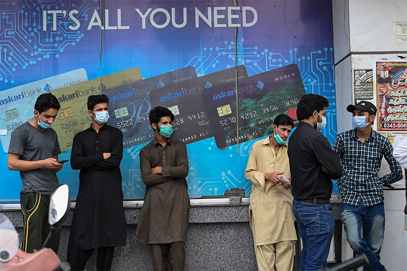 People queue in a line to enter a bank branch in Rawalpindi on May 5, 2021. (AFP)