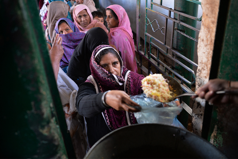 Pakistani residents receive donated food at a distribution point at the Bari Imam shrine in Islamabad on February 9, 2017. (AFP)