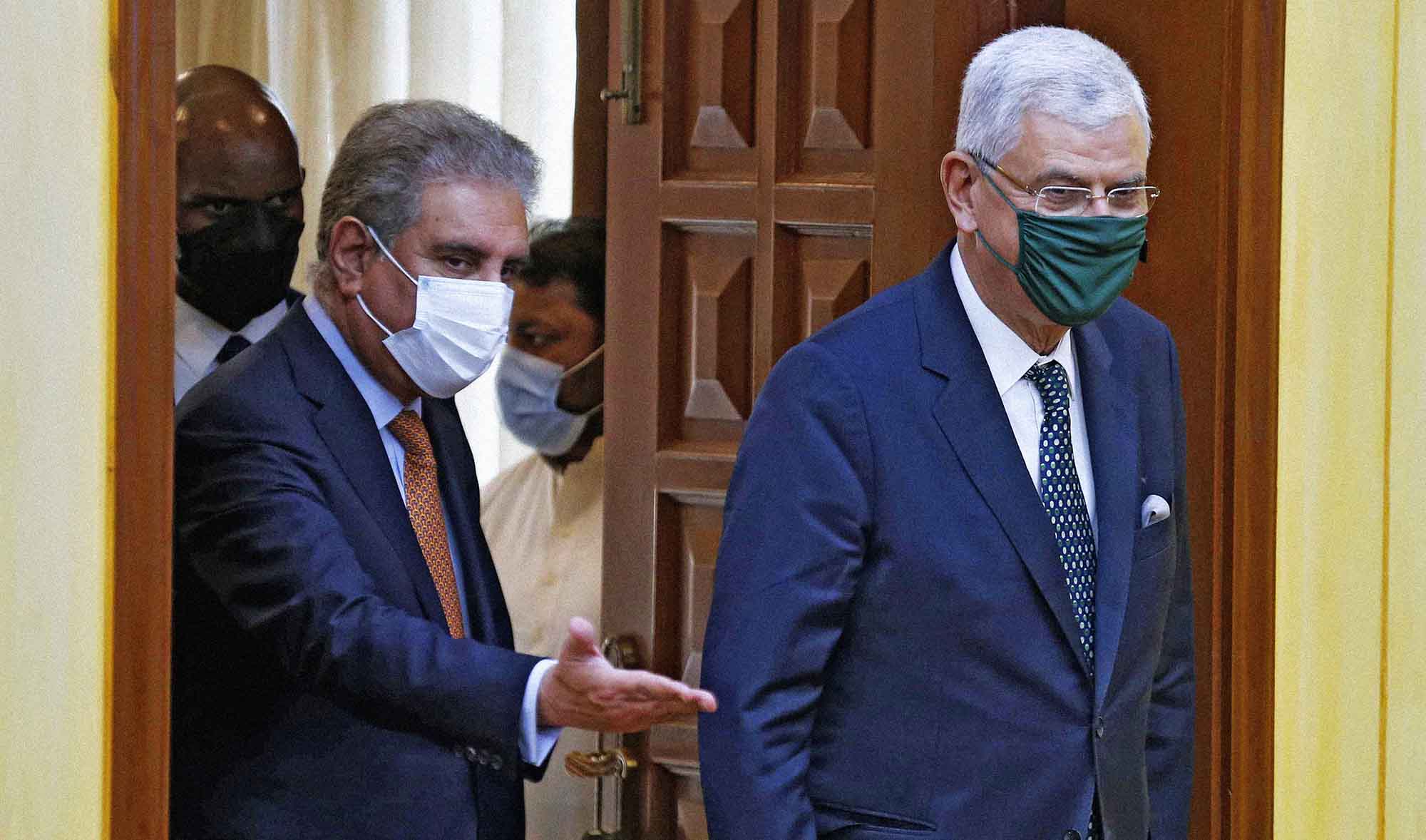 Pakistan's Foreign Minister Shah Mahmood Qureshi, right, and UN General Assembly President Volkan Bozkir arrive for a joint press conference, in Islamabad, Pakistan, on May 27, 2021. (AP)