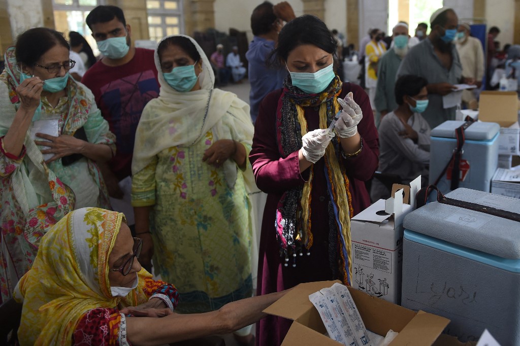 A health worker prepares to inoculate a woman with a dose of the Sinopharm vaccine at a vaccination center in Karachi on May 23, 2021. (AFP)