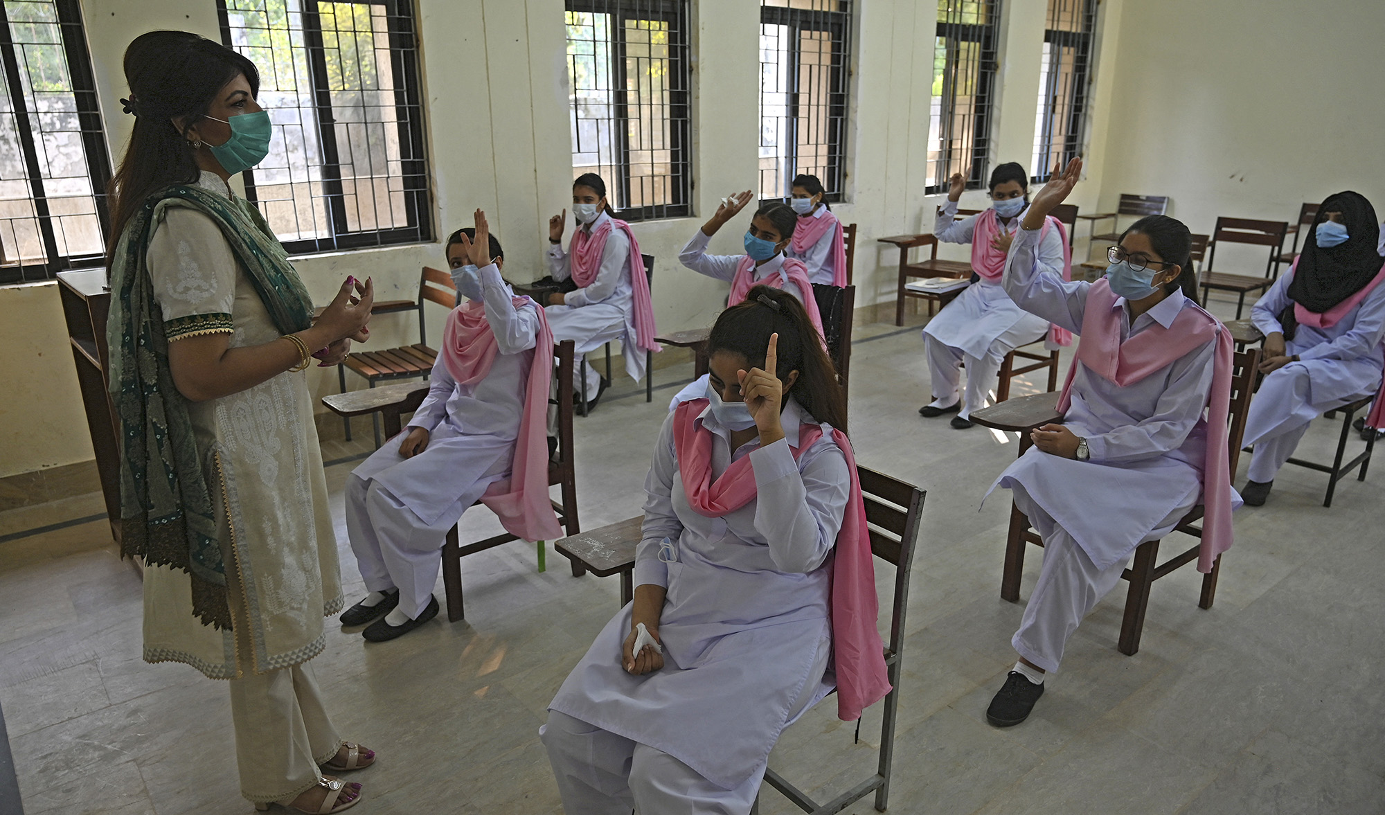 Principal Saba Faisal, left, takes the class of students at the Islamabad Model College of Commerce for Girls in Islamabad, Pakistan, on September 15, 2020. (AFP/File)