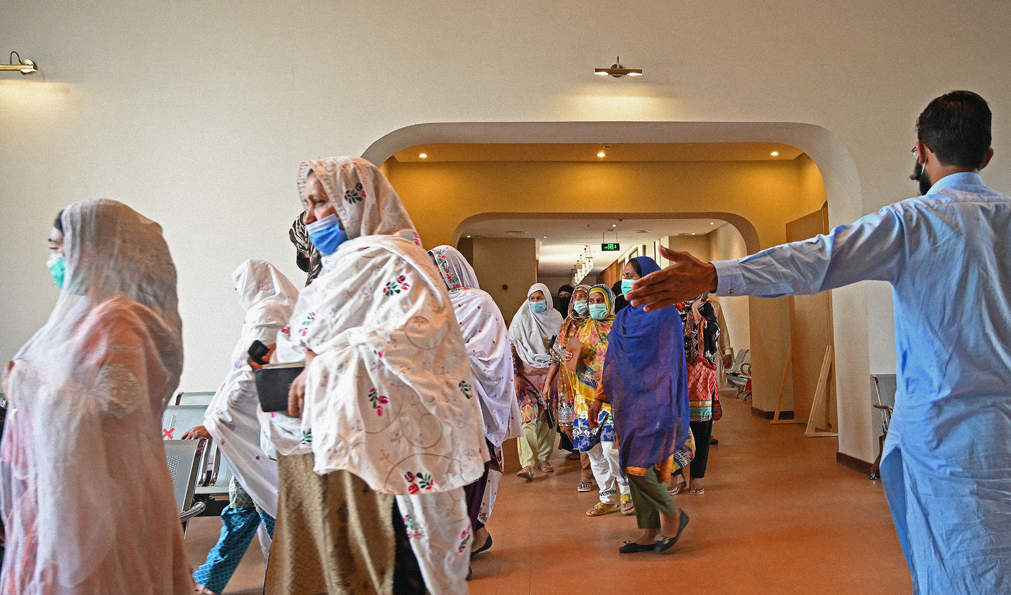 People arrive to get themselves registered and inoculated with the jab of Covid-19 coronavirus vaccine at a vaccination center in Islamabad, Pakistan, on May 22, 2021. (AFP)