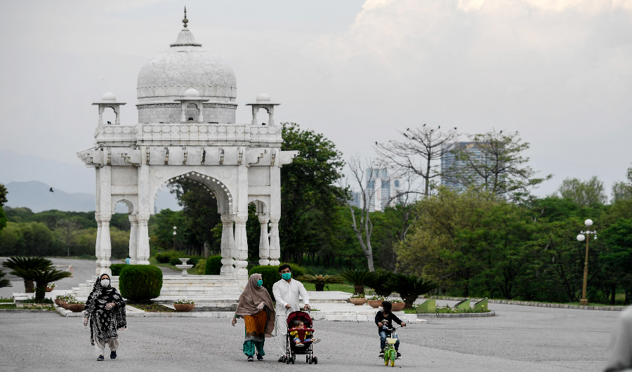 People wearing facemasks walk at the Fatima Jinnah Park in Islamabad on April 29, 2020. (AFP)
