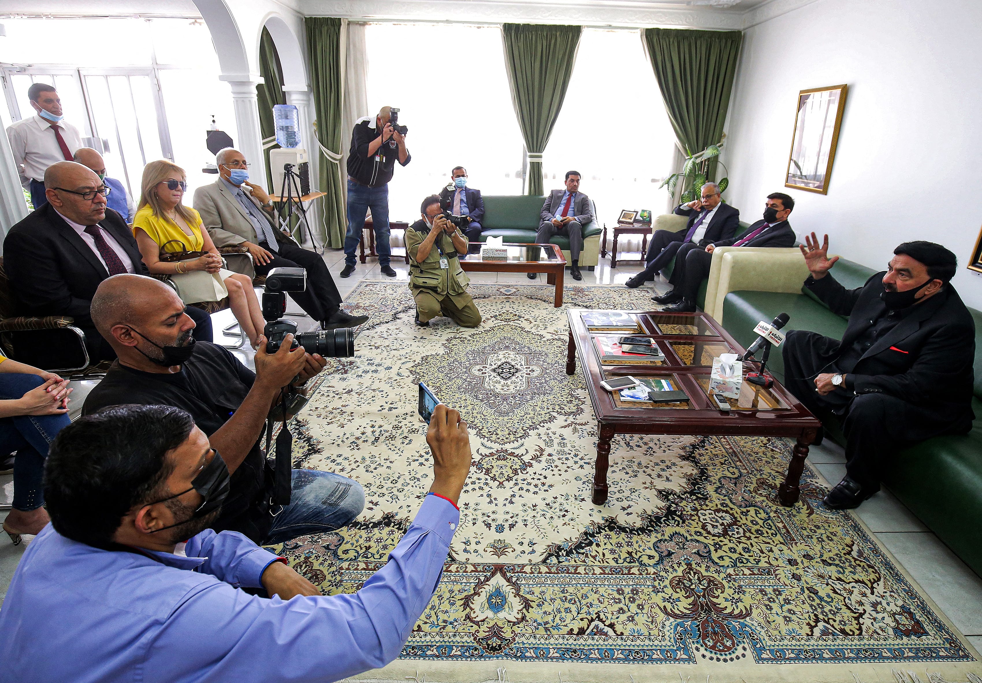 Pakistan's Interior Minister Sheikh Rasheed Ahmad (R) speaks to reporters at the Pakistani embassy in Kuwait City on May 31, 2021. (AFP)