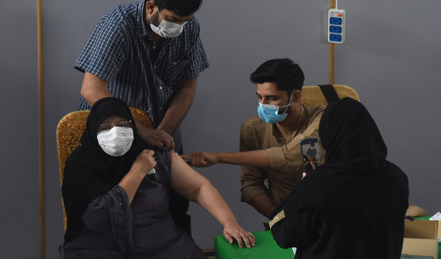 A health worker inoculates a woman with a dose of the Covishield AstraZeneca-Oxford's Covid-19 coronavirus vaccine at a vaccination centre in Lahore on May 23, 2021. (AFP)