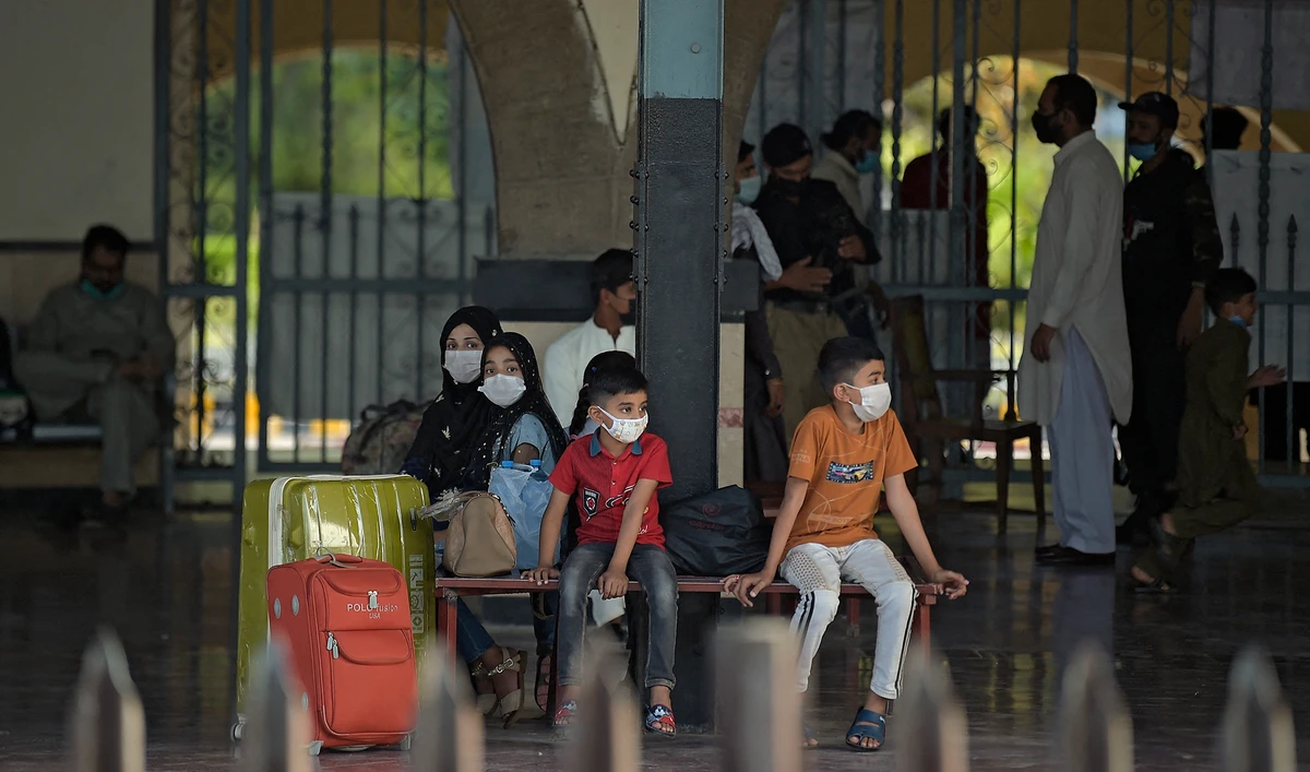 A family waits for a train during a nine-day shutdown in a bid to prevent a surge in Covid-19 cases on Eid Al-Fitr, in Rawalpindi, Pakistan, on May 11, 2021. (AFP)