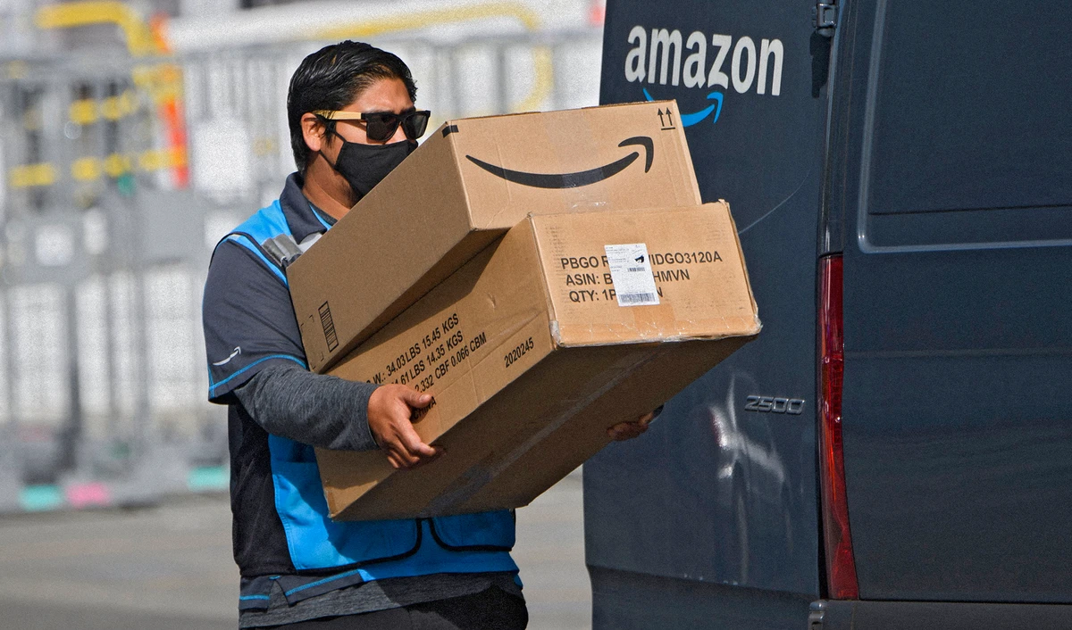 An Amazon.com Inc. delivery driver carries boxes into a van outside of a distribution facility on February 2, 2021 in Hawthorne, California. (AFP/File)