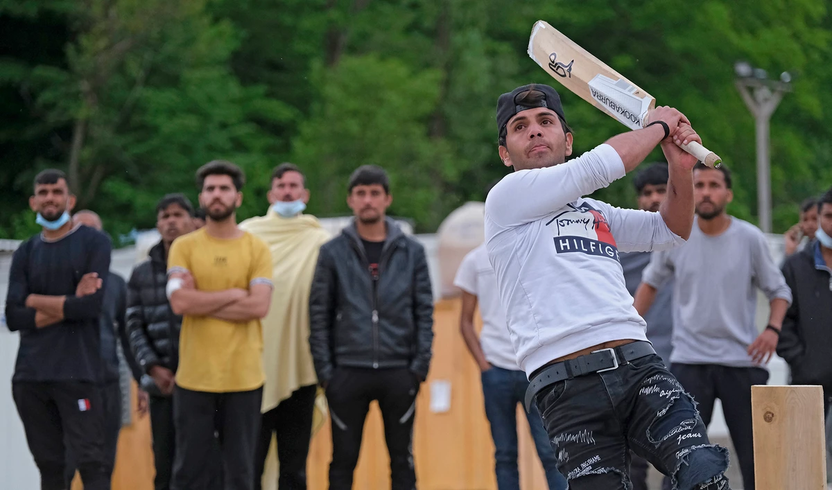 A batter hits the ball as migrants play a game of cricket in Blazuj migrant camp in Bosnia's capital of Sarajevo on May 19, 2021. (AP)