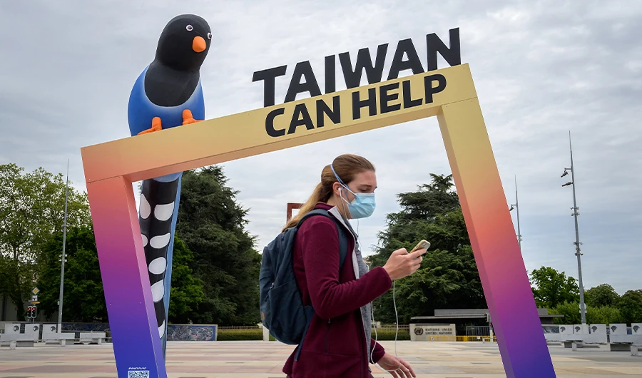 A woman walks by an arch reading "Taiwan can help" next to the building of the United Nations Offices in Geneva on the opening day of the WHO's World Health Assembly on May 24, 2021 in Geneva. (AFP)