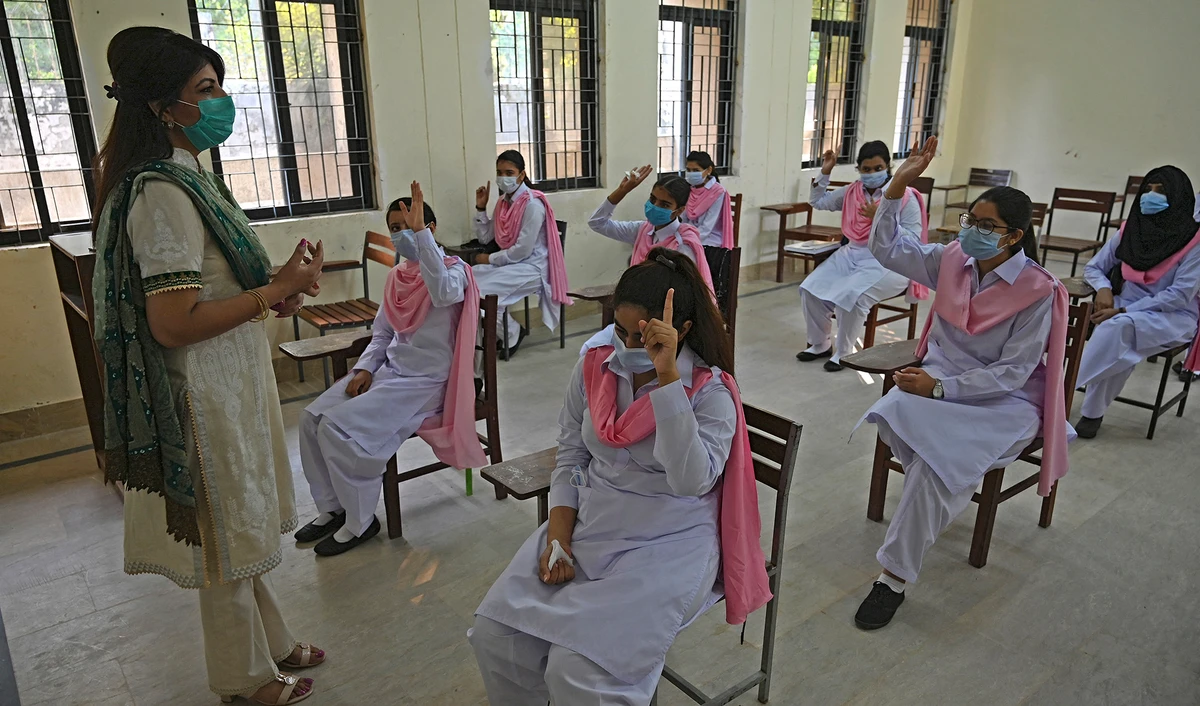 Principal Saba Faisal, left, takes the class of students at the Islamabad Model College of Commerce for Girls in Islamabad, Pakistan, on September 15, 2020. (AFP/File)