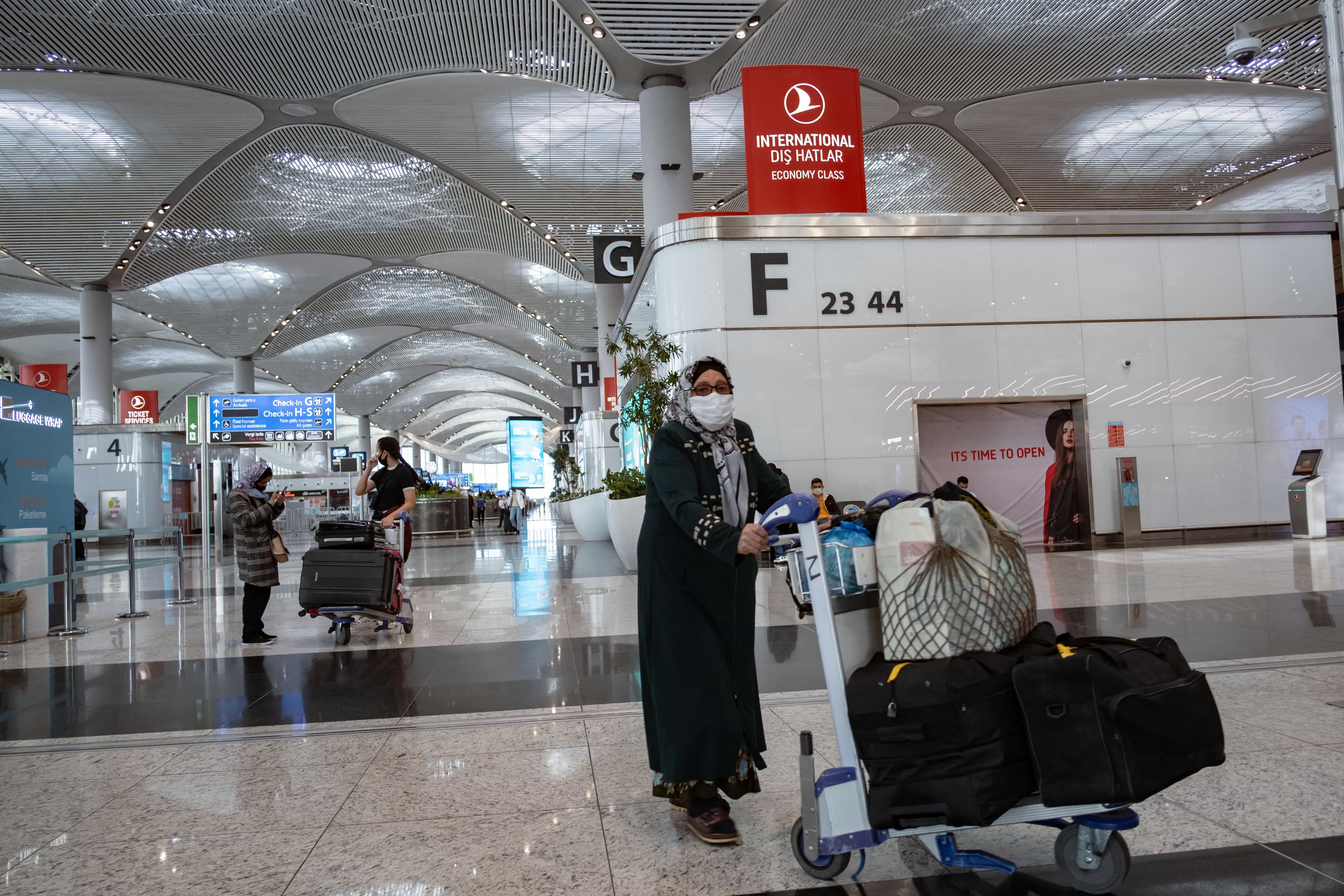 A passenger wearing a protective face mask walks through Istanbul Airport on the first day of the resumtion of domestic flights which were halted since March 26 due to the spread of the novel coronavirus, COVID-19, in Istanbul on June 1, 2020. (AFP)
