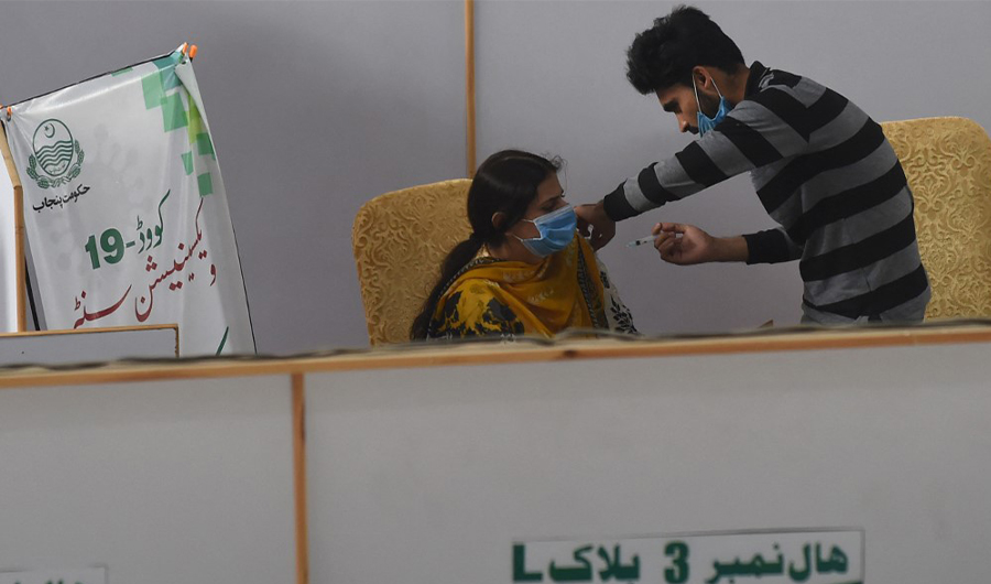 A health worker inoculates a woman with a dose of the Covishield AstraZeneca-Oxford's Covid-19 coronavirus vaccine at a vaccination centre in Lahore on May 23, 2021. (AFP)
