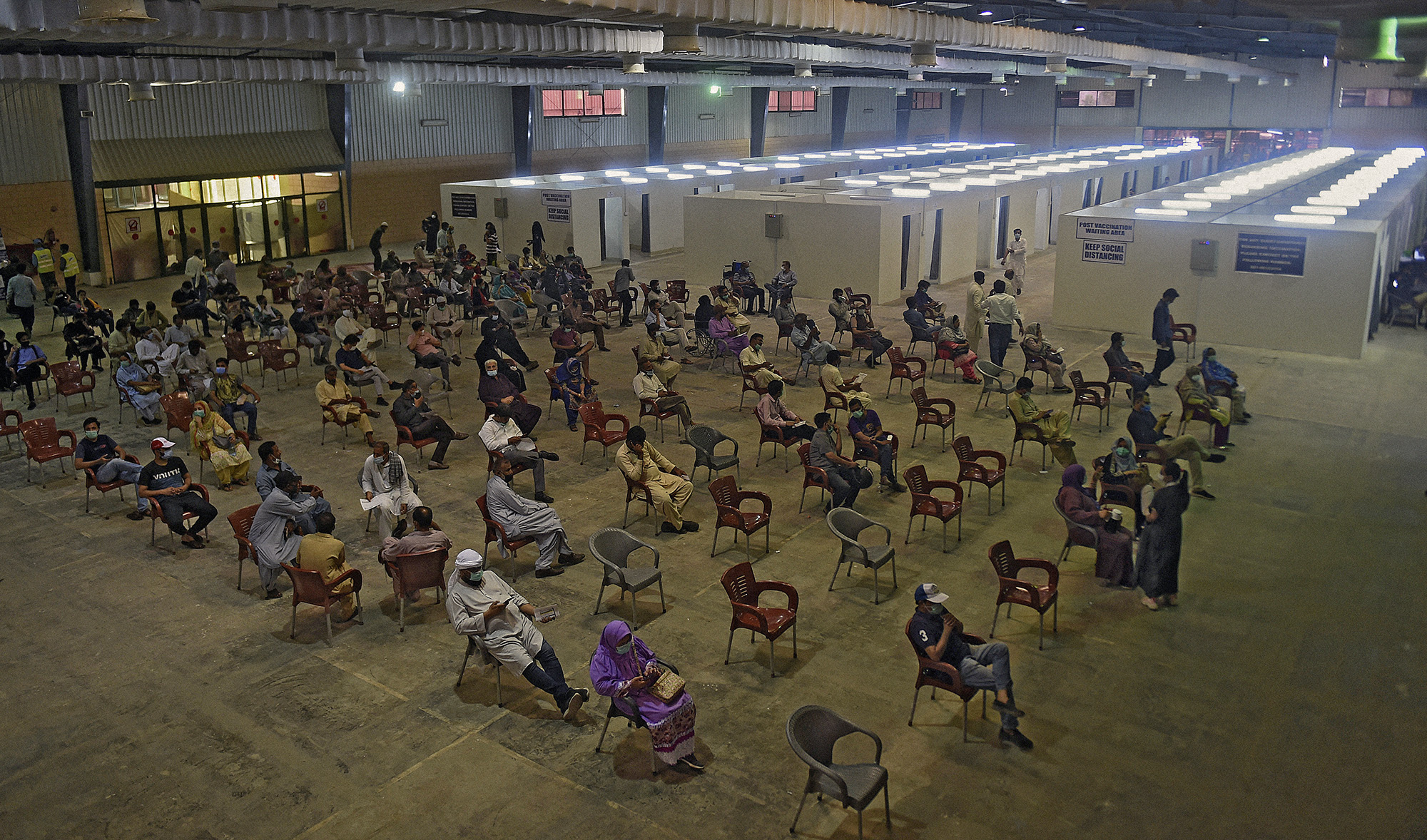 People wait for their turn to receive a dose of the Covid-19 coronavirus Sinovac vaccine at a vaccination camp organized at expo center in Karachi, Pakistan, on June 3, 2021. (AFP)