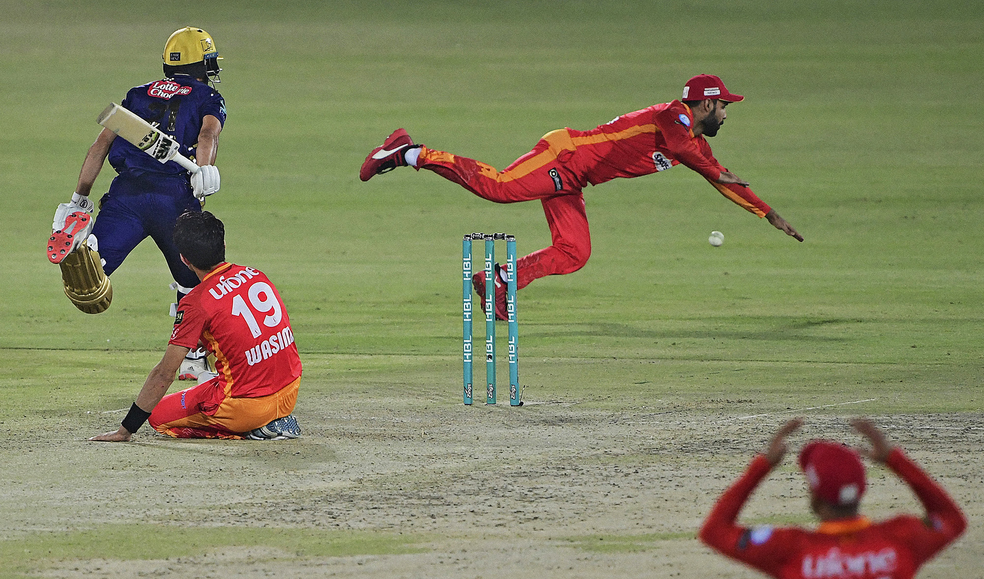 Islamabad United's Shadab Khan (2R) fields the ball as Quetta Gladiators' Mohammad Nawaz (R) takes a run during the Pakistan Super League match between Islamabad United and Quetta Gladiators in Karachi on March 2, 2021. (AFP/File)