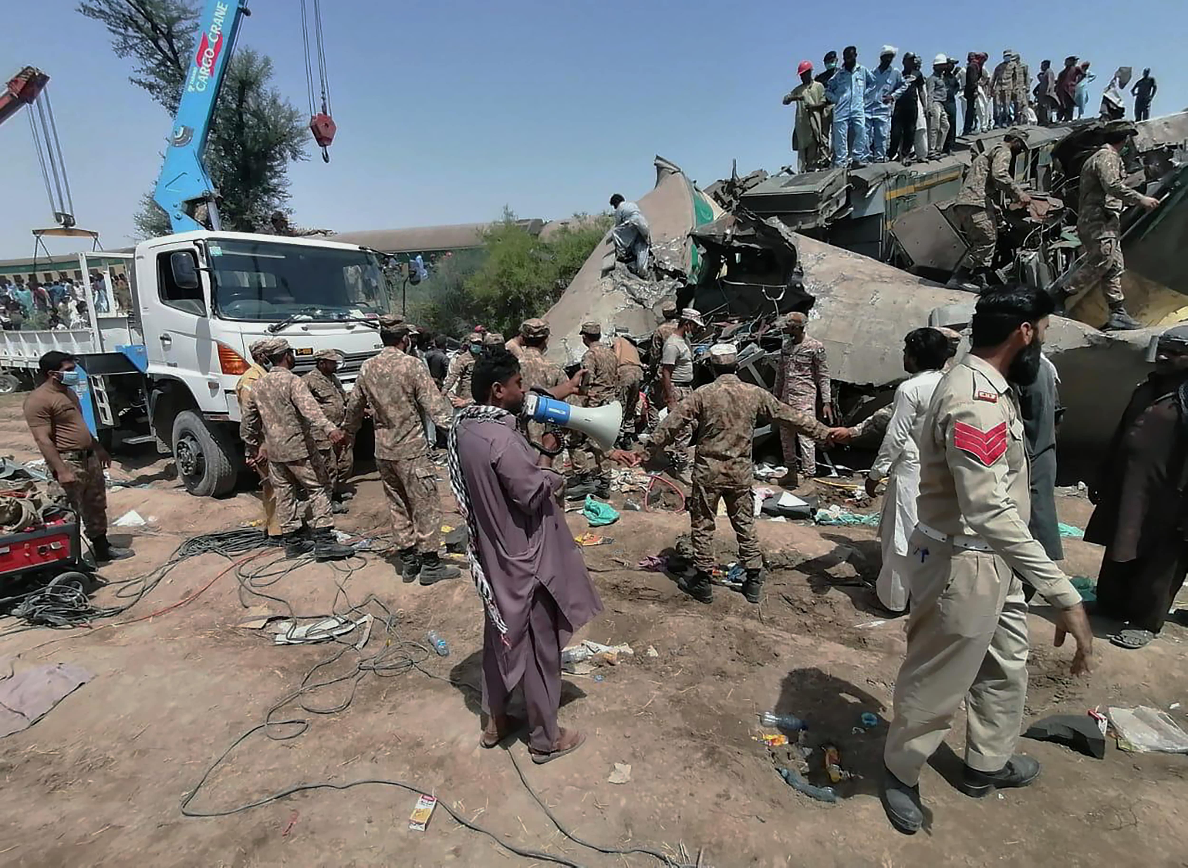 In this photo released by Pakistan's army media wing Inter Services Public Relations, troops and rescuers work at the site of a train collision in Ghotki district in the southern Pakistan, Monday, June 7, 2021. (Inter Services Public Relations vis AP)