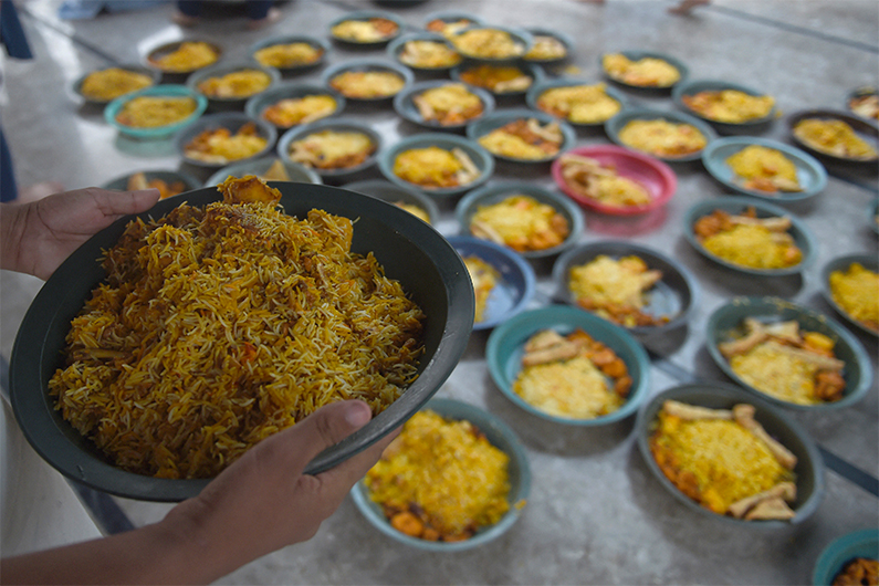 A man prepares food plates at the premises of a railway station in Karachi on April 16, 2021. (AFP)