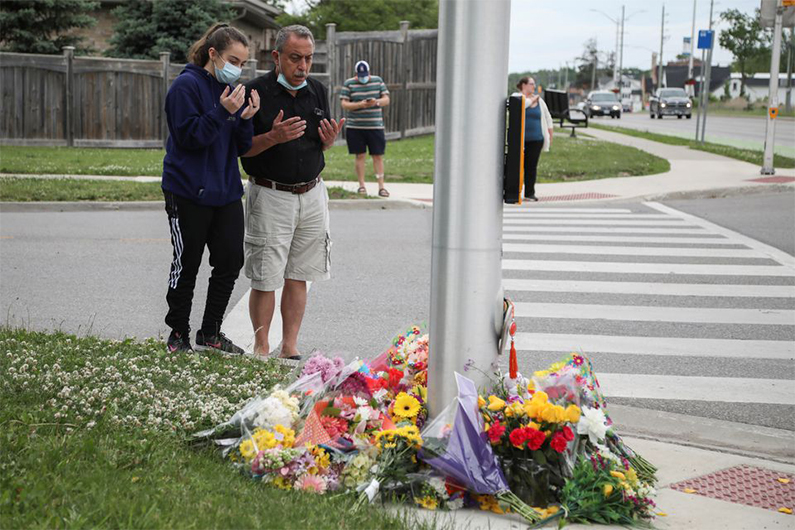 People say a prayer at the fatal crime scene where a man driving a pickup truck jumped the curb and ran over a Muslim family in what police say was a deliberately targeted anti-Islamic hate crime, in London, Ontario, Canada June 7, 2021. (REUTERS)