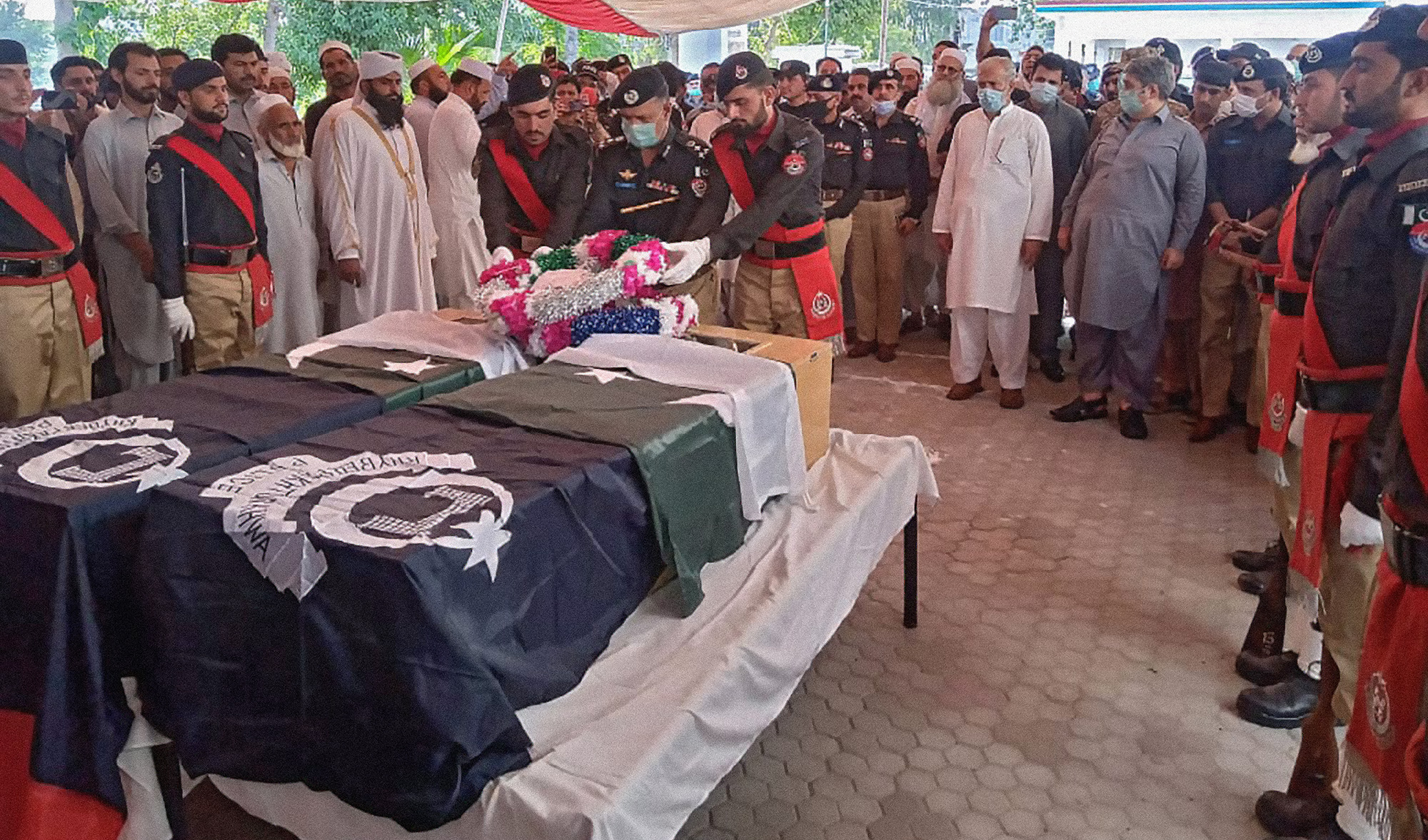 Pakistani police officials pay honor to two officers killed by gunmen while guarding a polio team in Mardan, Khyber Pakhtunkhwa, on June 9, 2021. (Photo courtesy: KP Director General Information and Public Relations)