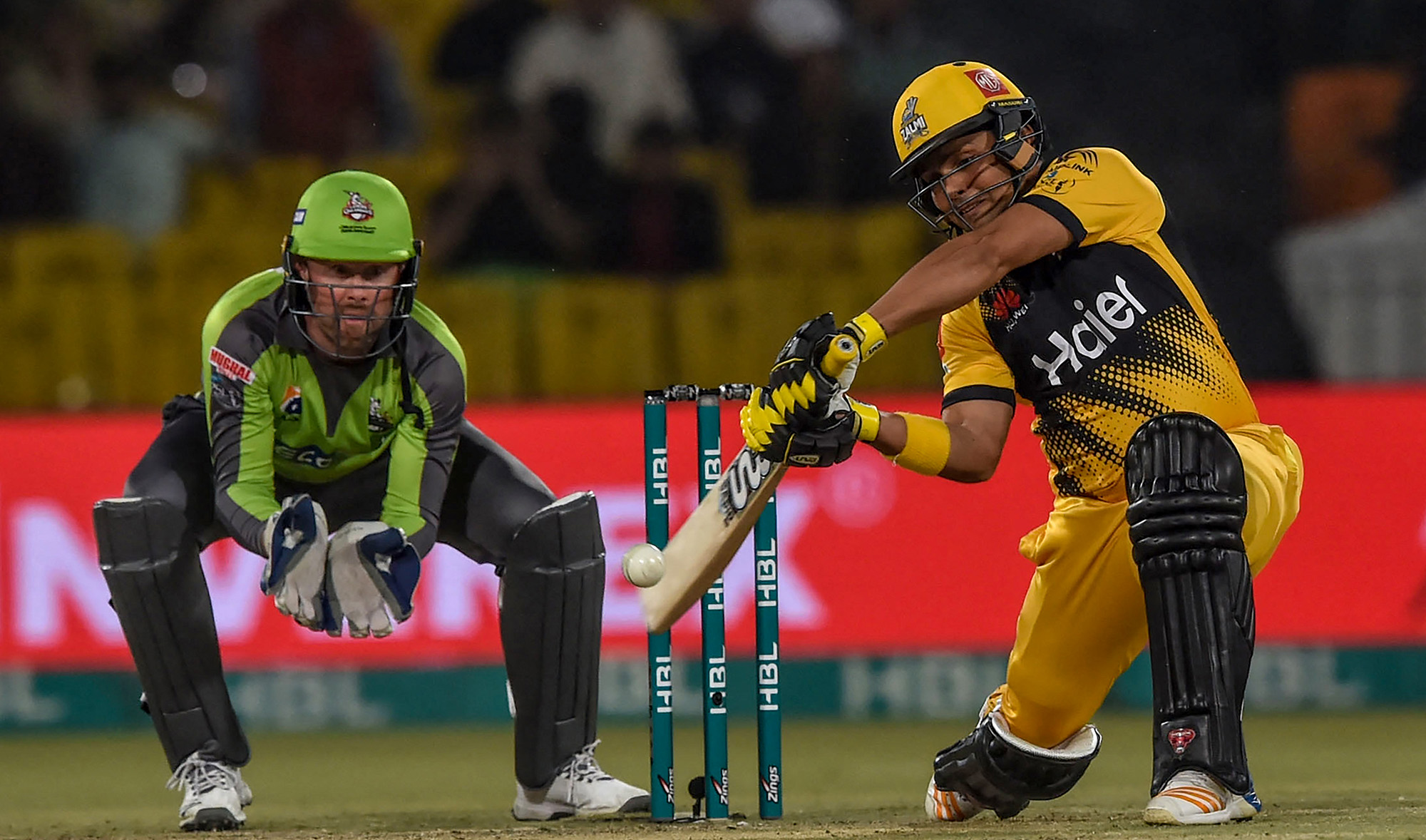Peshawar Zalmi's Kamran Akmal, right, plays a shot next to Lahore Qalandars' Ben Dunk during the T20 cricket match in Lahore, Pakistan, on March 10, 2020. (AFP/File)
