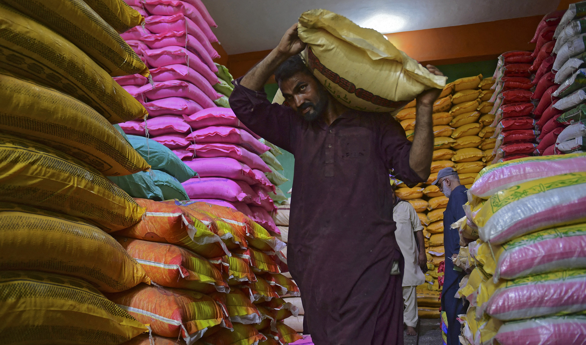 A worker carries a rice bag at a store in Karachi on June 10, 2021. (AFP)