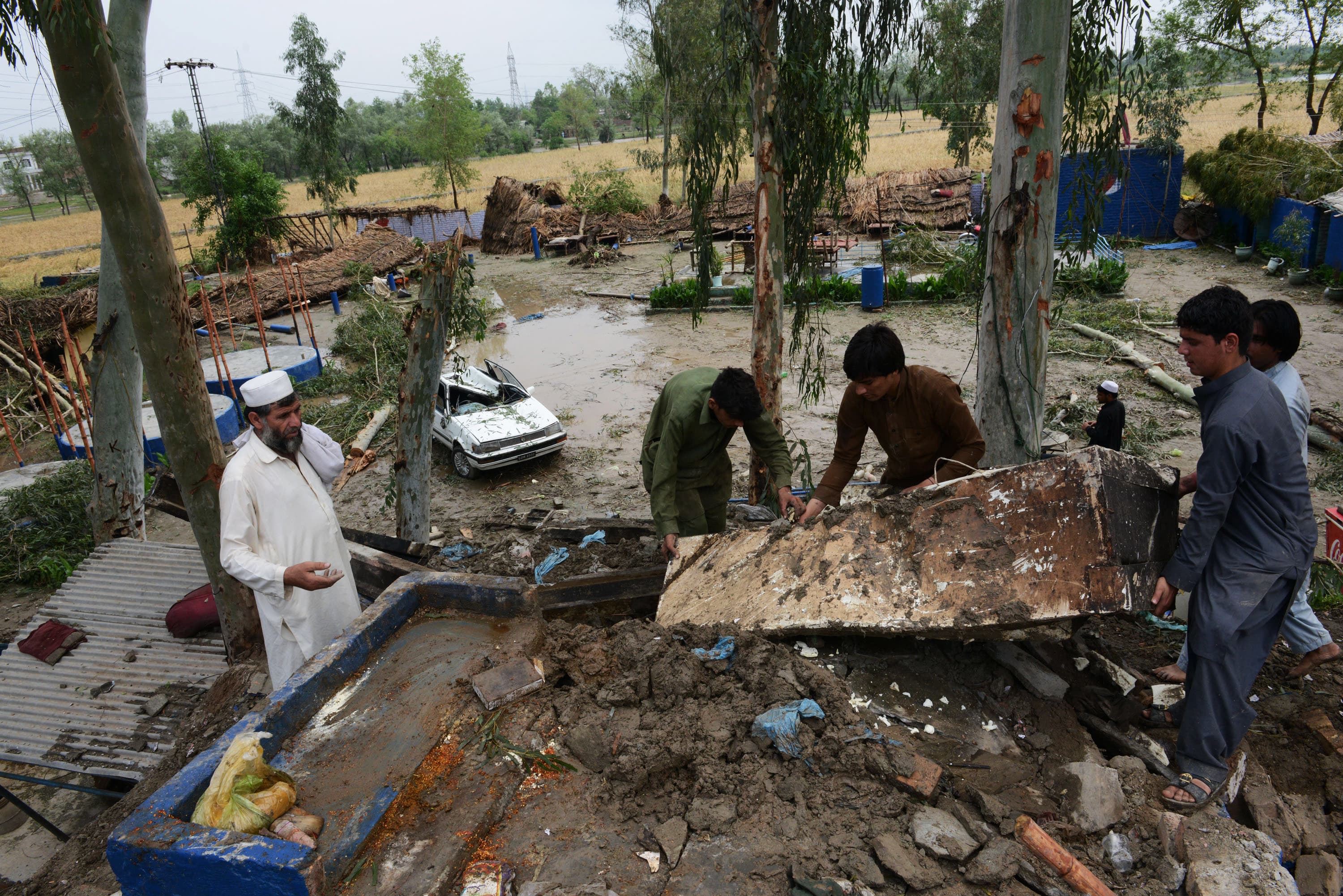 Pakistani residents collect belongings at their home after it was damaged in heavy rain and winds in Peshawar on April 27, 2015. (AFP/ File)