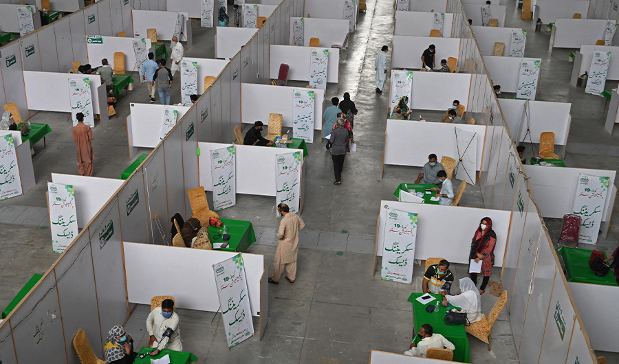Health workers inoculate people with the dose of coronavirus vaccine at a vaccination center in Lahore, Pakistan, on May 23, 2021. (AFP)