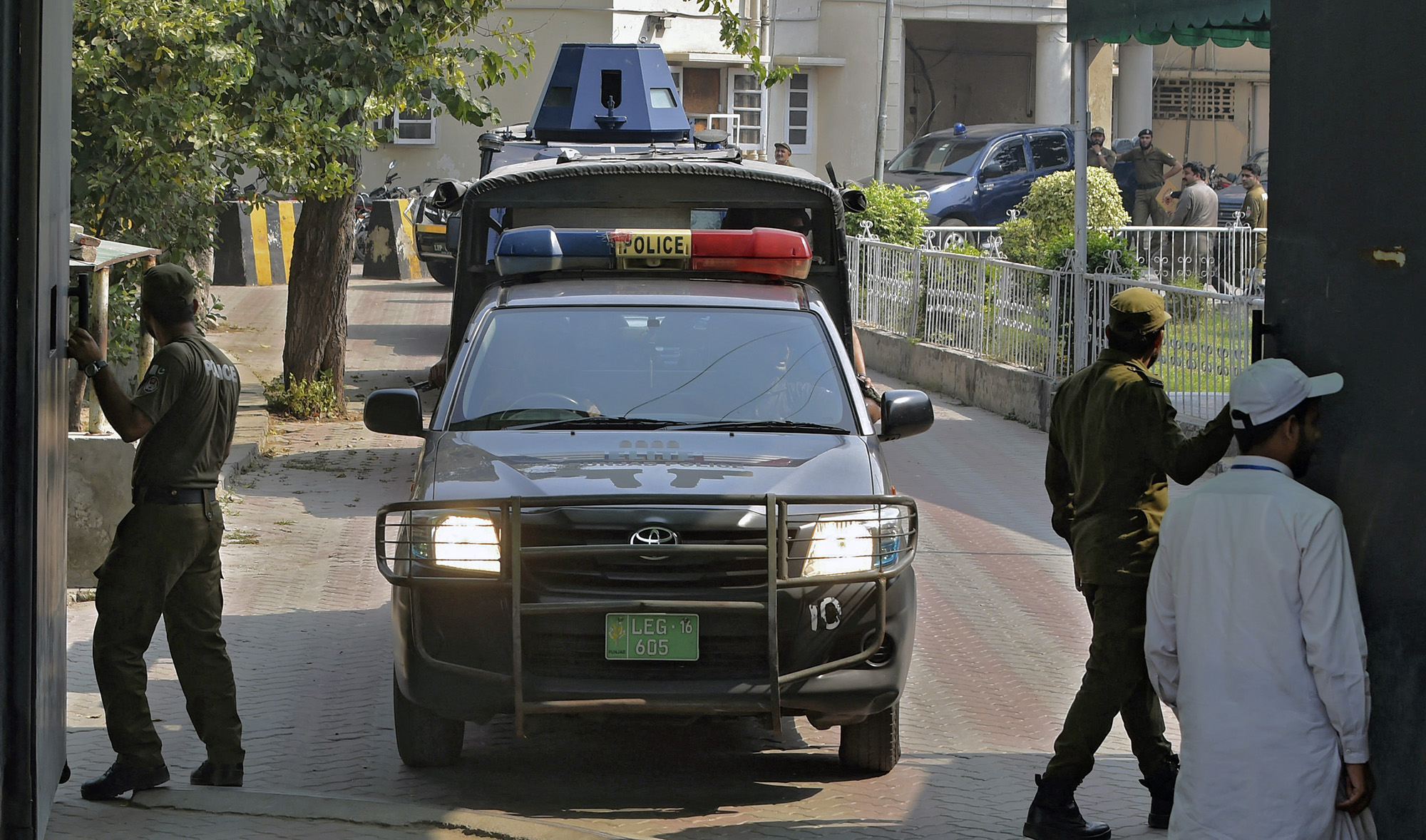 A police car escorts an armed vehicle carrying a suspect of a gang rape as they leave the court premises in Lahore, Pakistan, on October 13, 2020. (AFP/File)