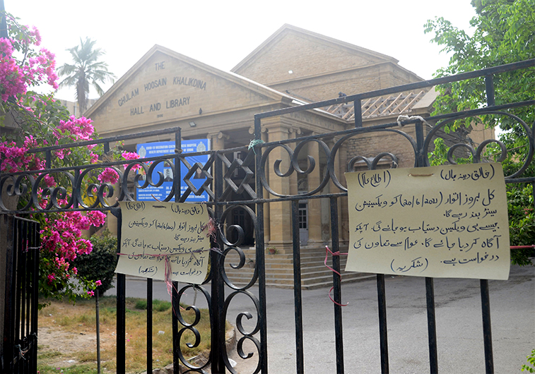 In this photograph taken on June 20, 2021, a notice outside Khalikdina Hall Vaccination Center in Karachi, Sindh province, reads: "Tomorrow on Sunday, 20/6/2021. (AN photo/SA Babar)